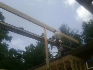 Carpenter setting a ridge beam over a new addition frame — Ice Dam Removal by Roofing Brothers in Malden On Hudson