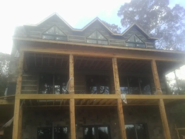 Dormers and porch framing on a large log home under construction — Roof Coating work by our crew in Malden On Hudson