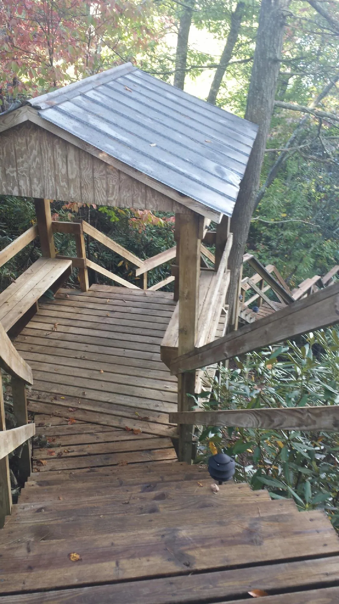Metal roofed shelter over wooden steps on a wooded walkway — Skylight Repair & Installation work by our crew in Malden On Hudson